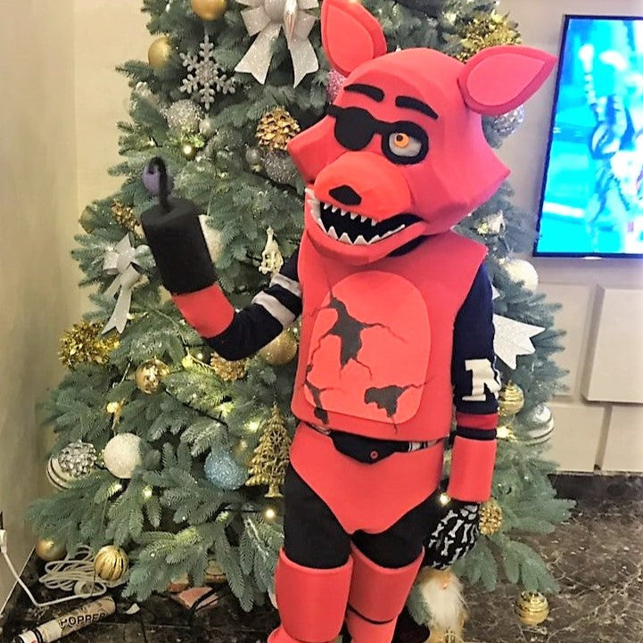 Kid wearing a red FNAF Foxy costume near the Christmas tree at home