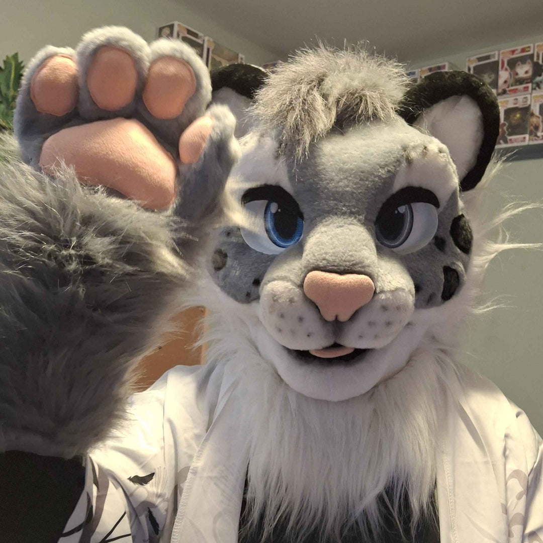 A person wearing gray leopard fursuit head with spots and hand paw s