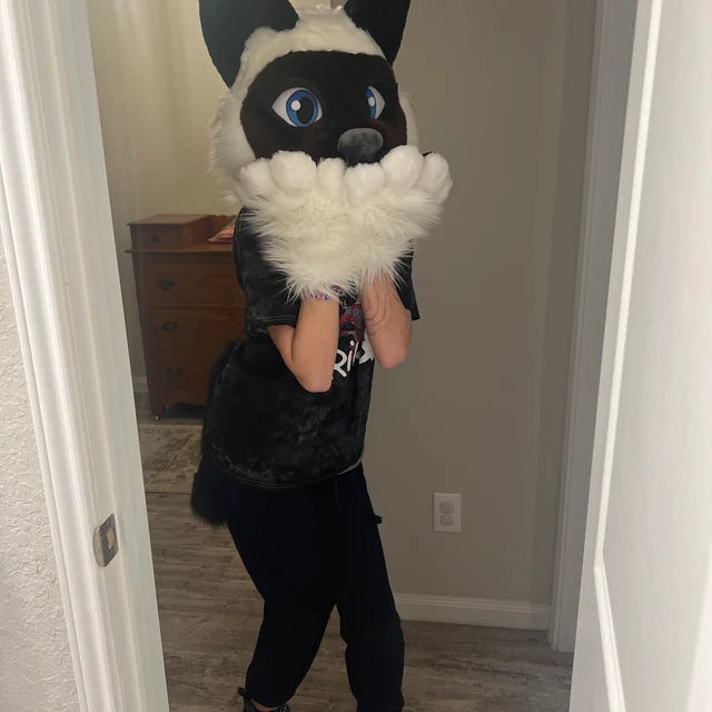 Little girl happily wearing a Siamese cat furry costume at home
