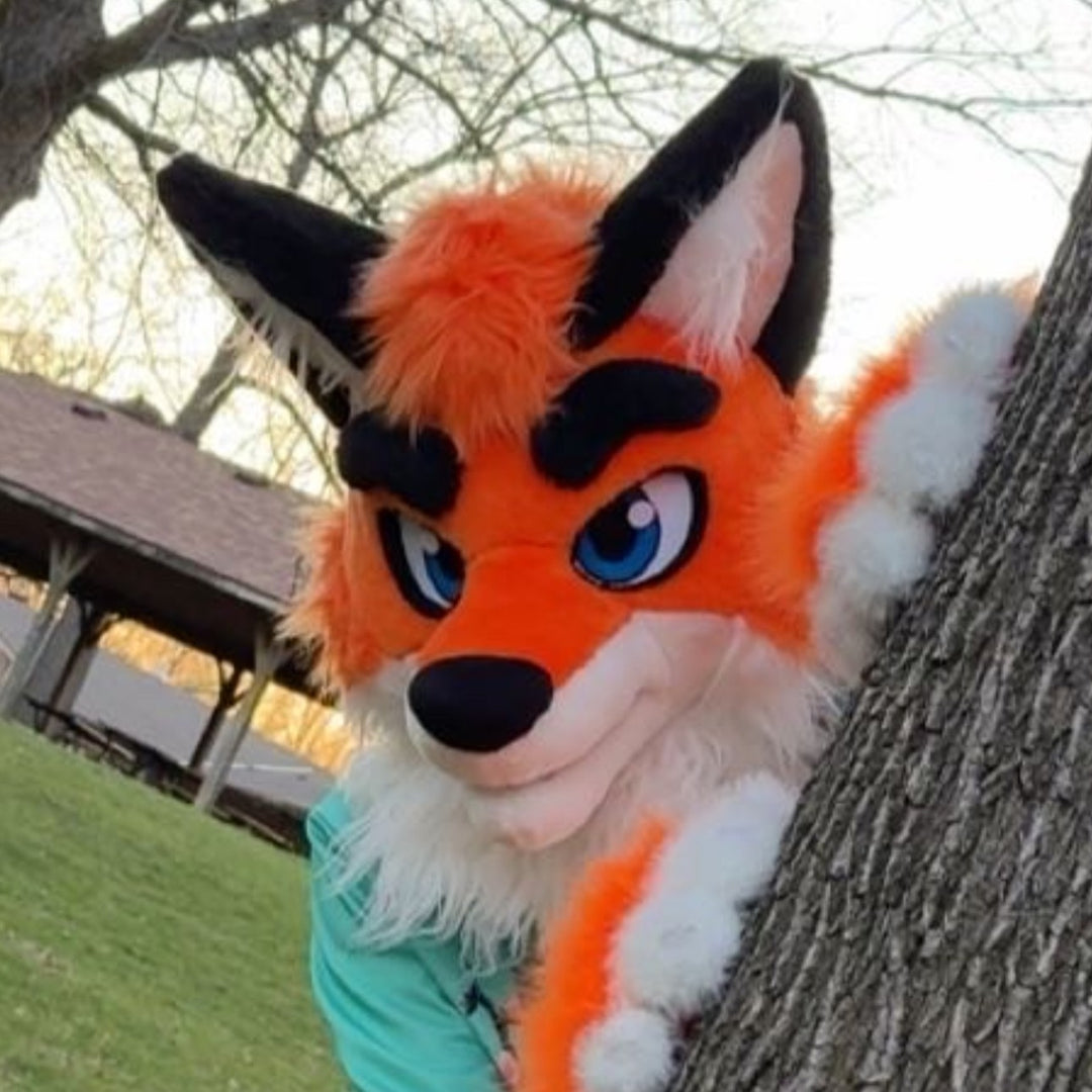 A person wearing bright orange fox fursuit head on a US farm 